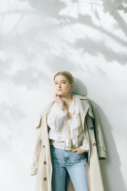 a woman is leaning against a wall with her hand on her chin