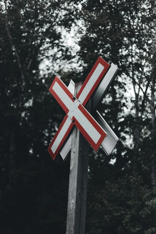 this cross on a post has a striped red and white pattern