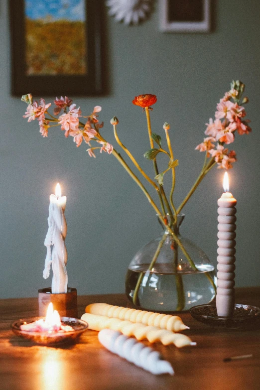 a wooden table topped with flowers and candles