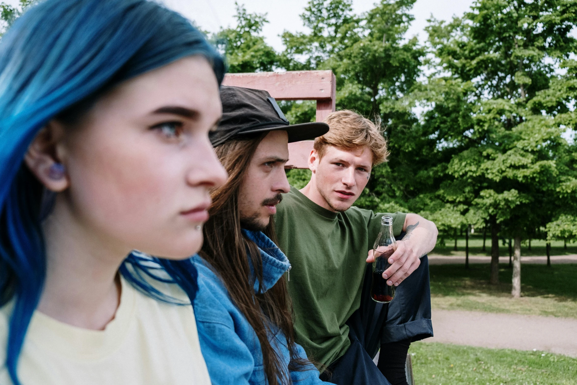 three people staring at soing while another watches from a bench