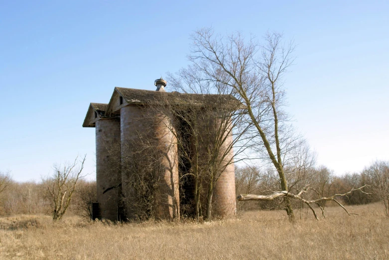 an old abandoned building stands alone in the middle of a field