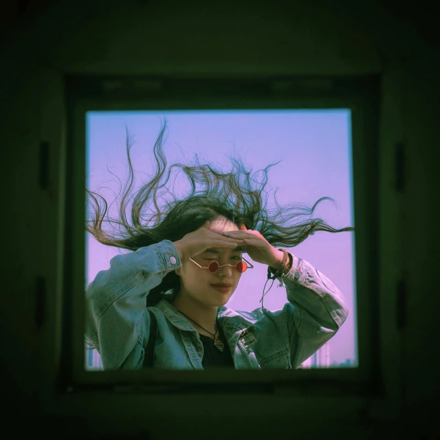 a woman is holding her hair in the wind