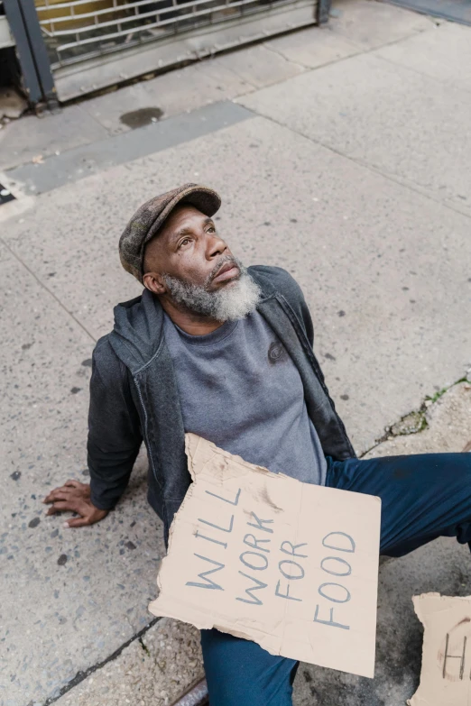 a man holds a sign outside on a sidewalk