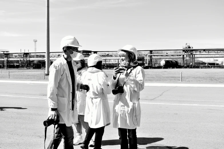 four people wearing matching white outfits on the street