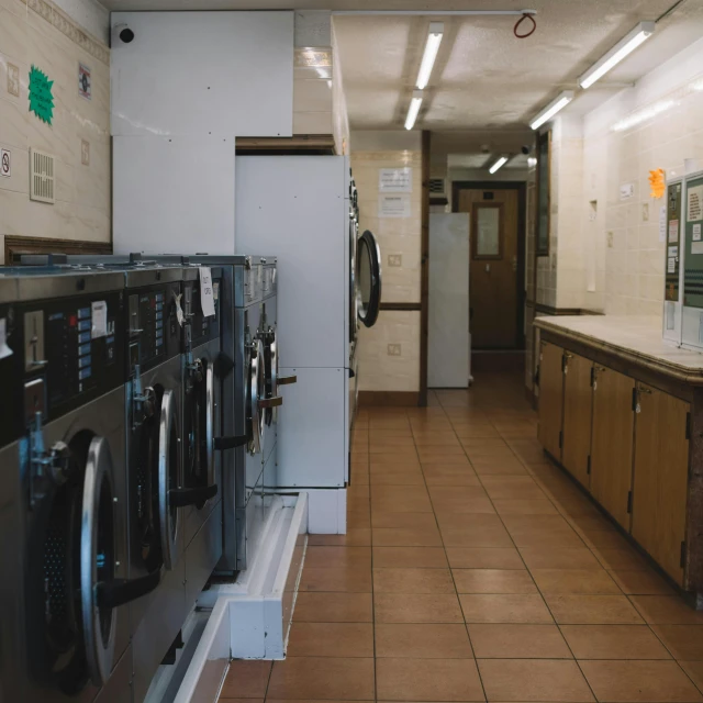 a row of dryers sitting inside of a laundry room