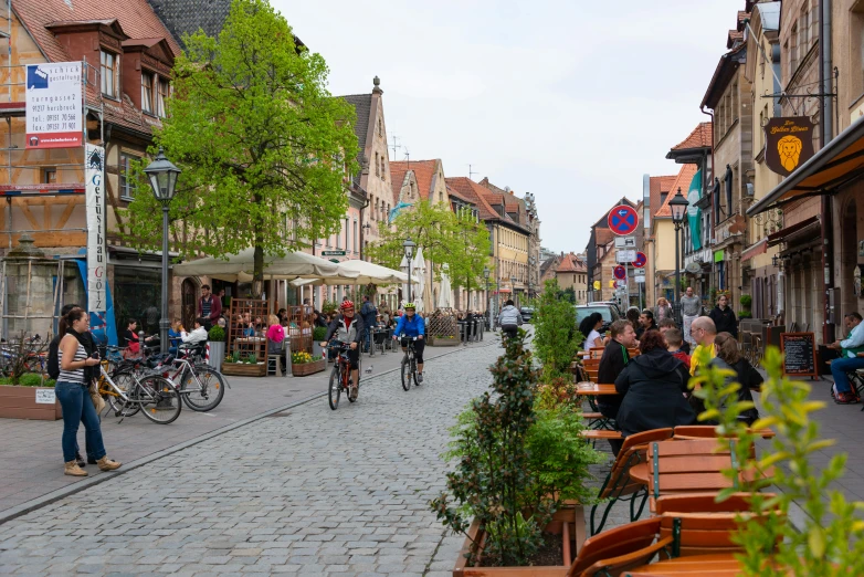 several people walk around an older european city street