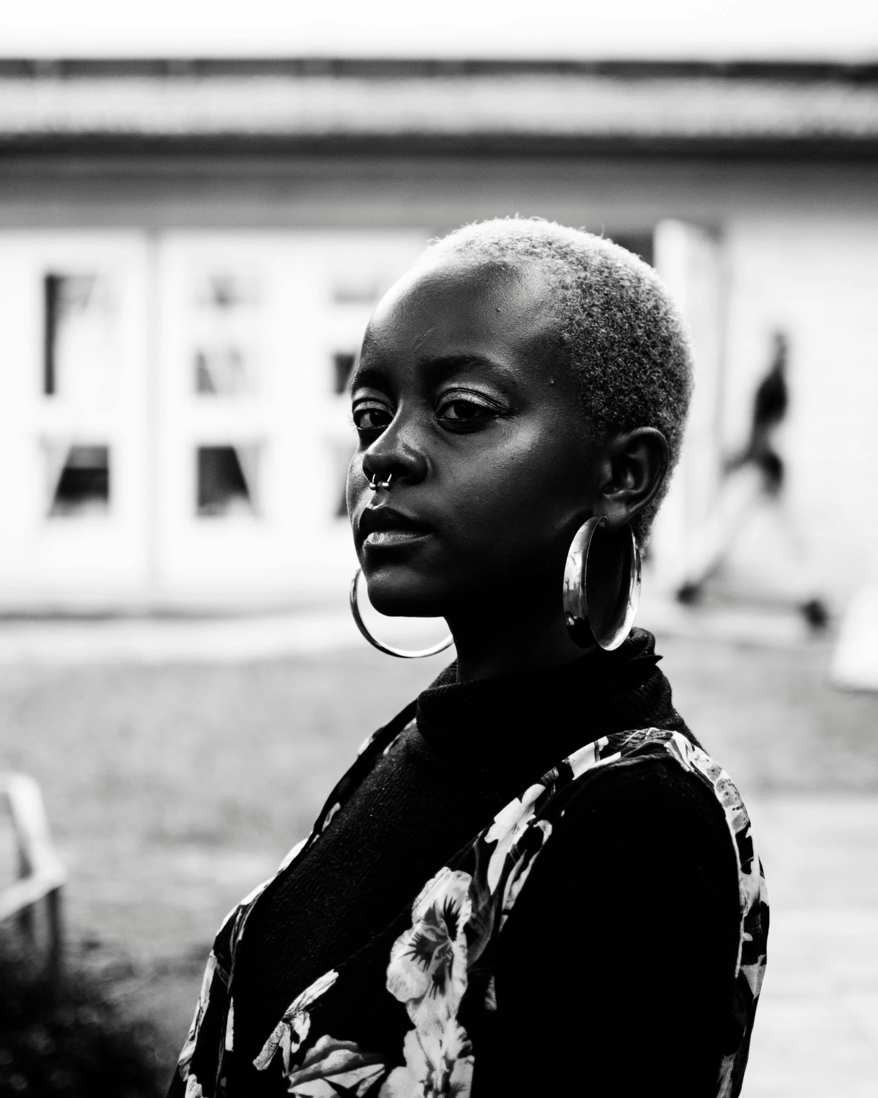 a black woman with large hoops standing in front of a building