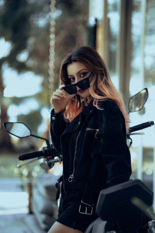 a woman is sitting on a motorcycle with a cellphone