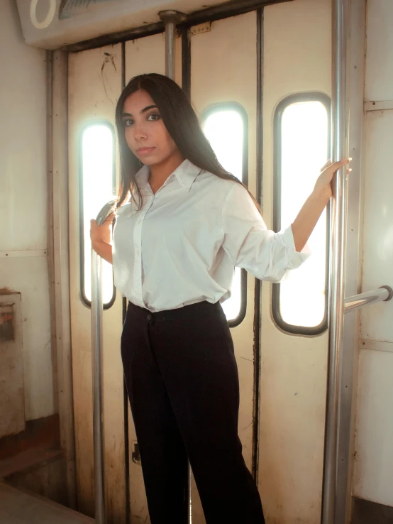 woman in black pants standing inside doorway next to an airplane