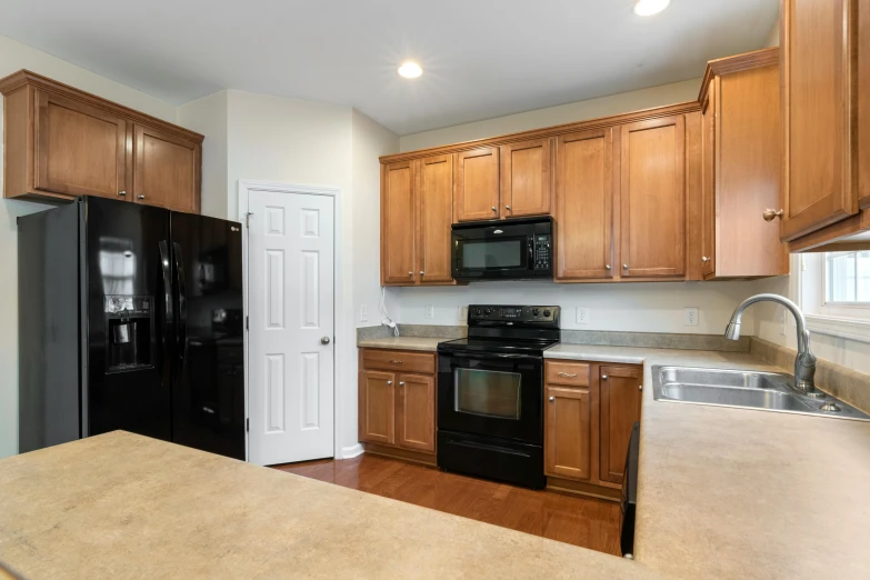 a clean and organized kitchen in an empty apartment