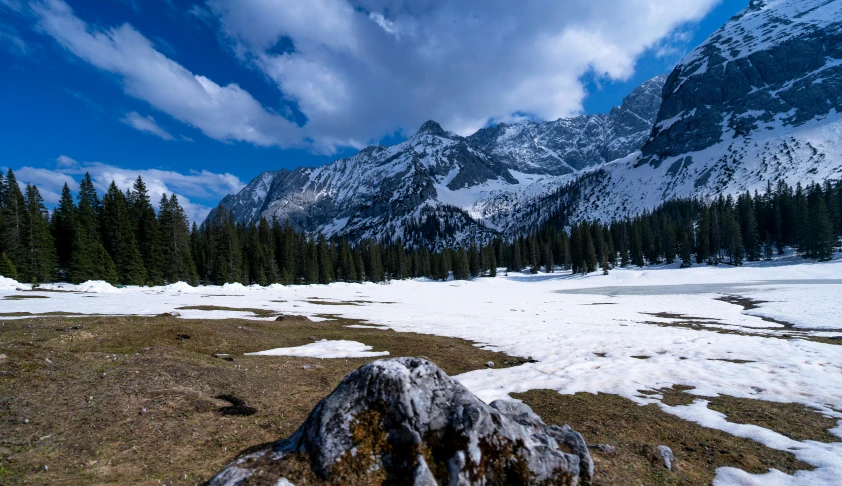 the snow covered ground has rocks in it