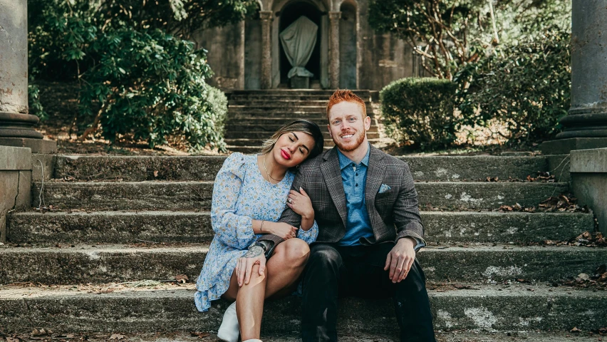 the couple are posing on the steps in the rain