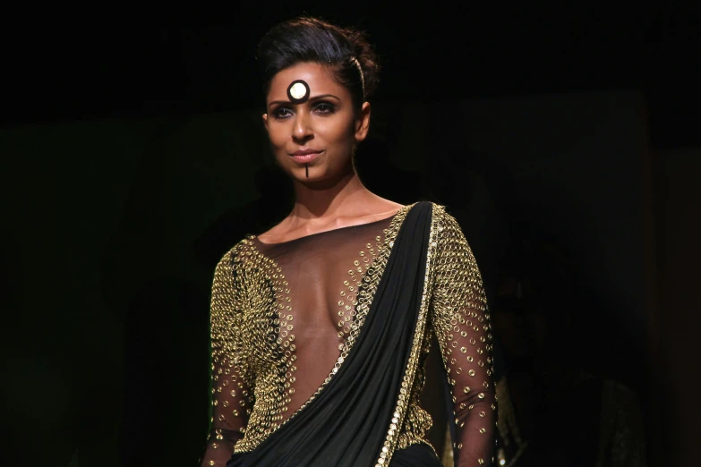 a woman in a black and gold sari