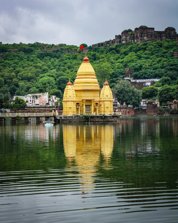 a temple that is by some water near a hill