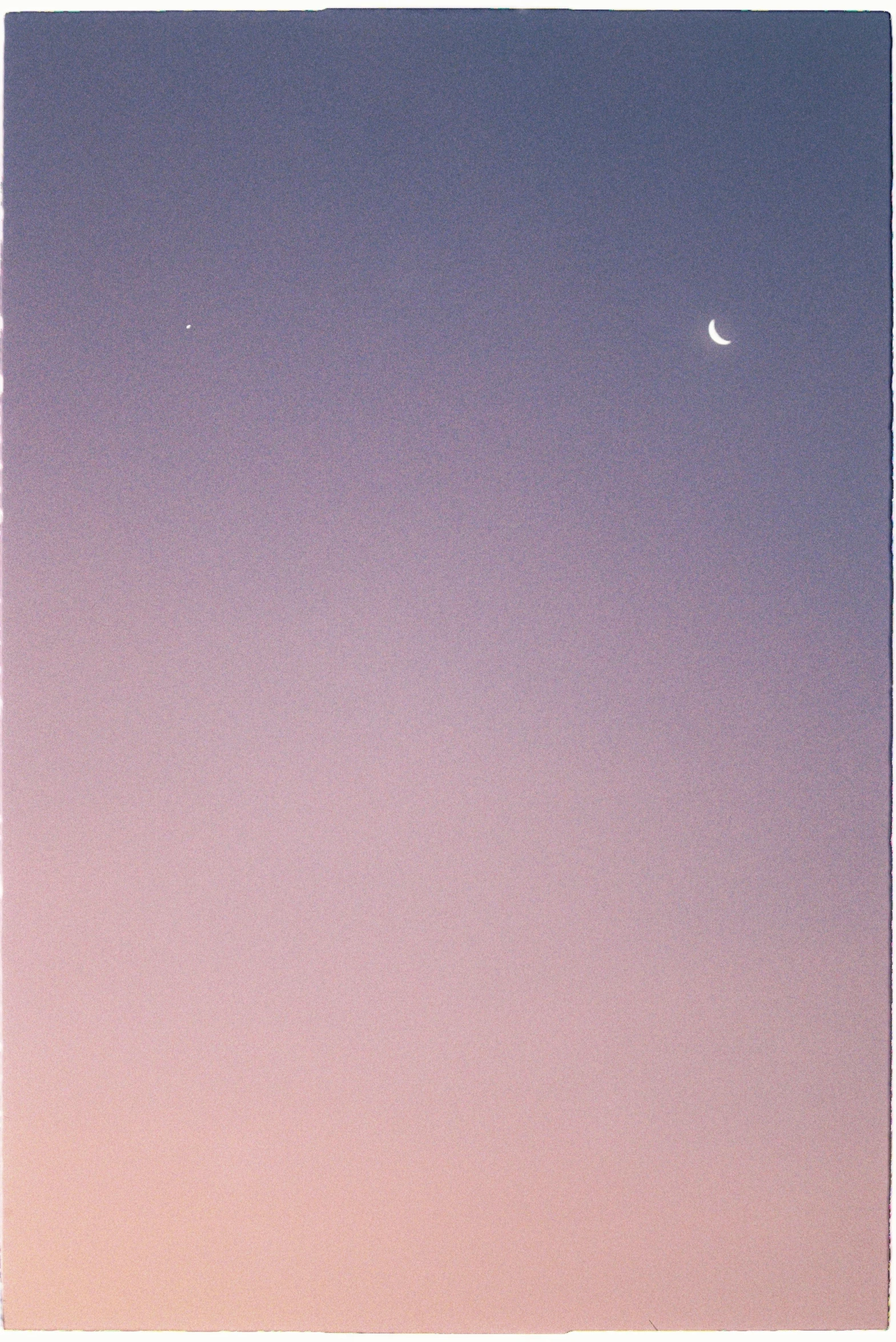 a clear blue sky with the moon in the distance