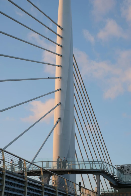 a view of the tall bridge with people crossing it