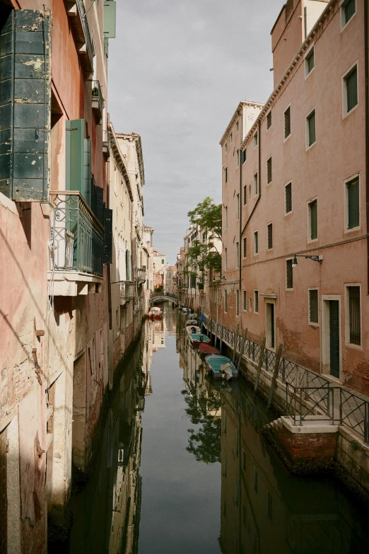 a very narrow and peaceful canal with small boats floating in it