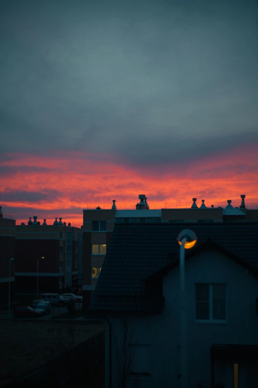 red sky at twilight, dark silhouette of buildings, houses and car