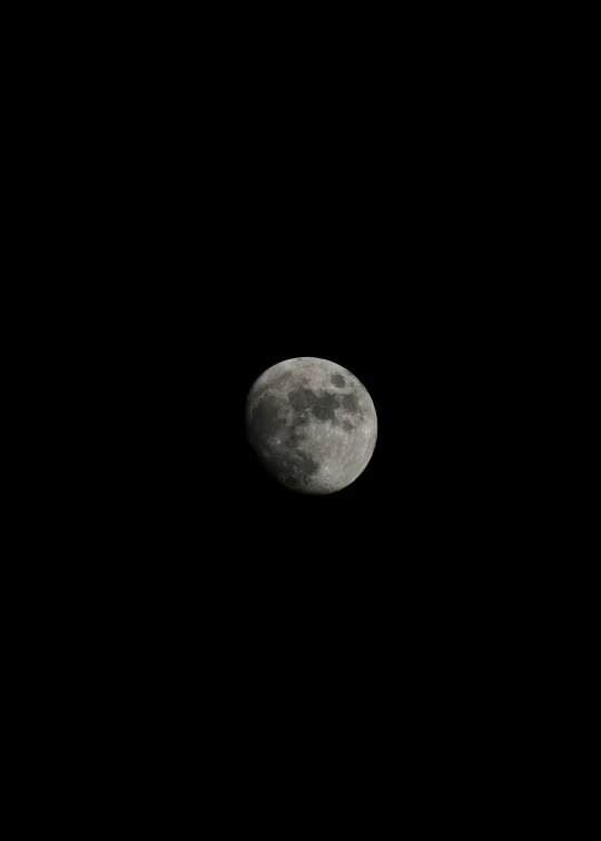 a single half moon shining on a black sky