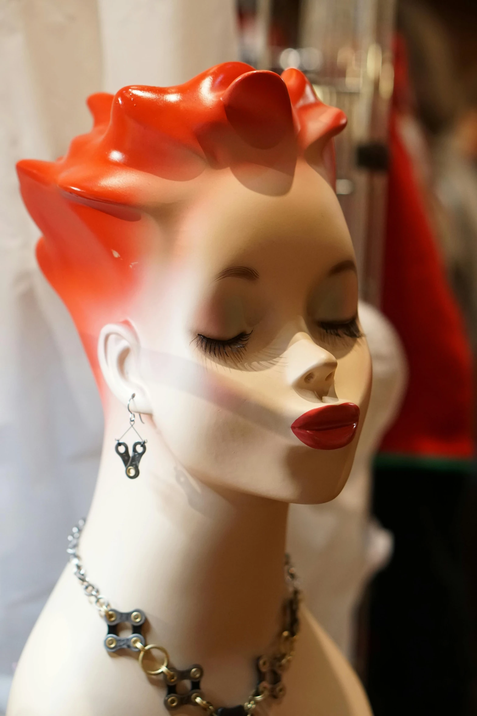 a white female mannequin head in front of clothing