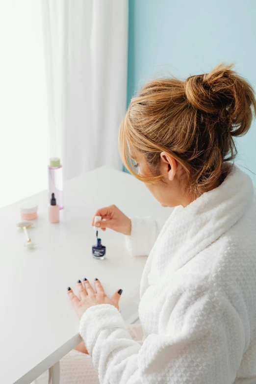 a woman in white robe decorating a white table