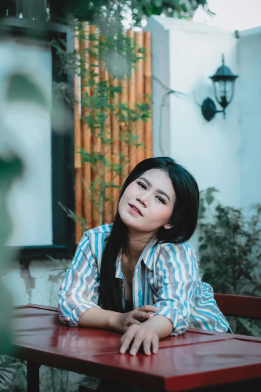 a woman sitting at a red table outside