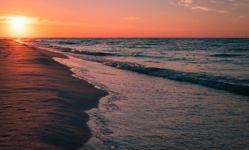 the sun is setting over the ocean with waves