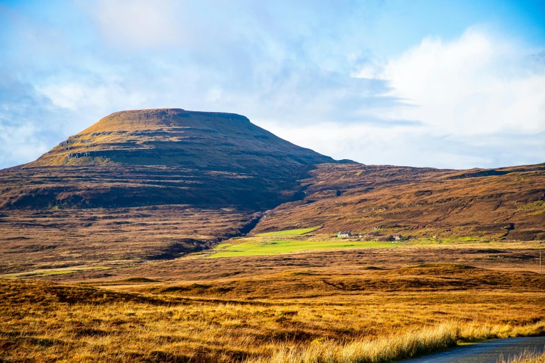 mountain in the background covered in brown grass