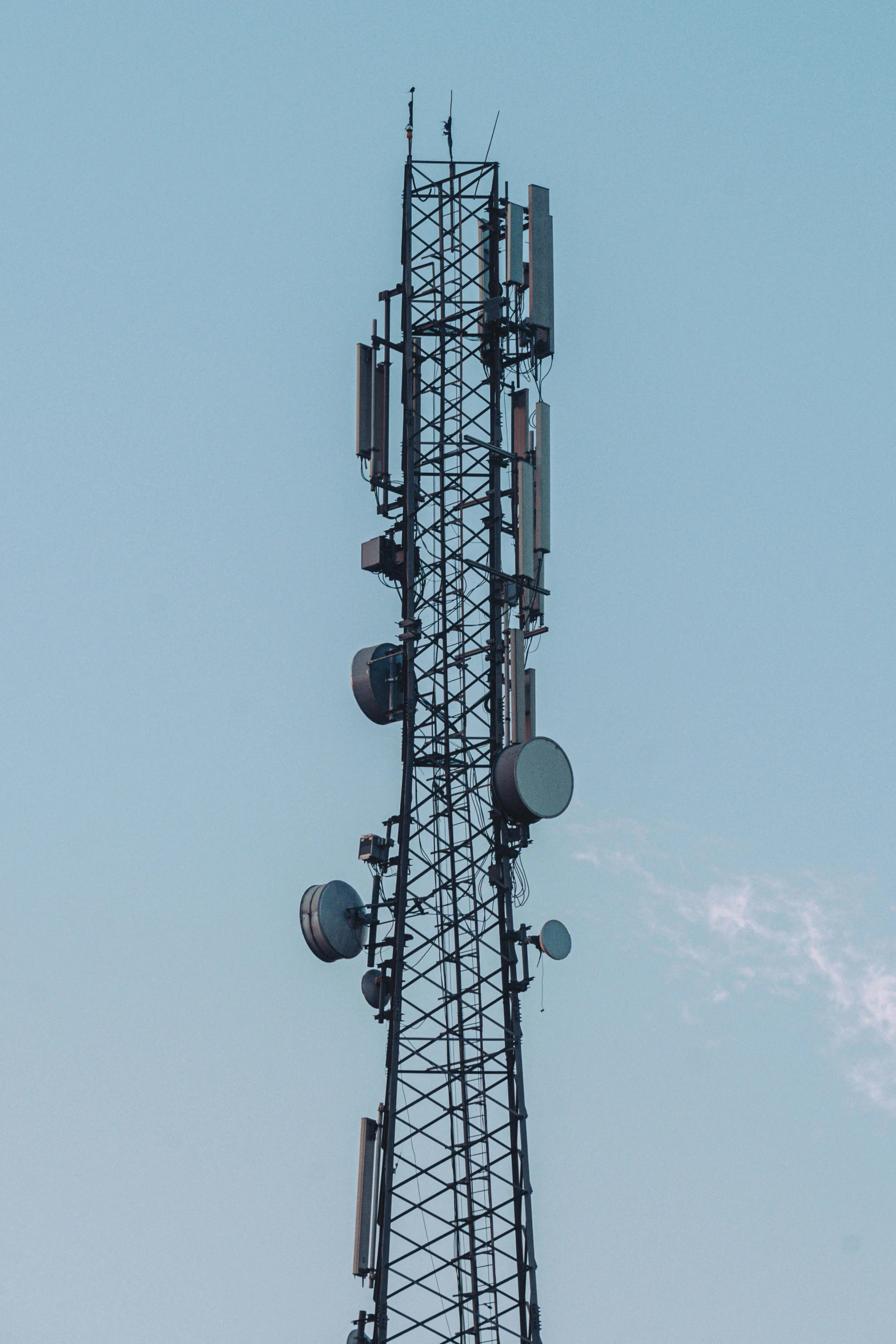 a tall structure with several cell towers in the sky