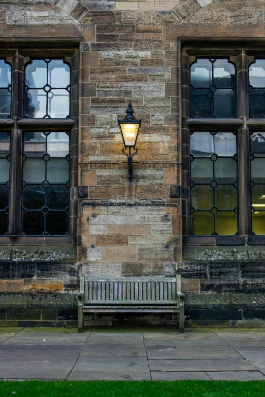 an empty bench near a building with stained glass windows