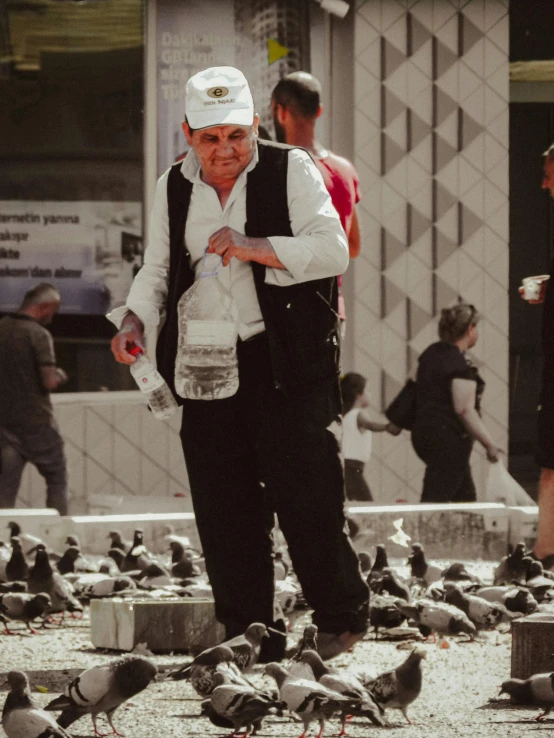 a man standing over a flock of birds and water