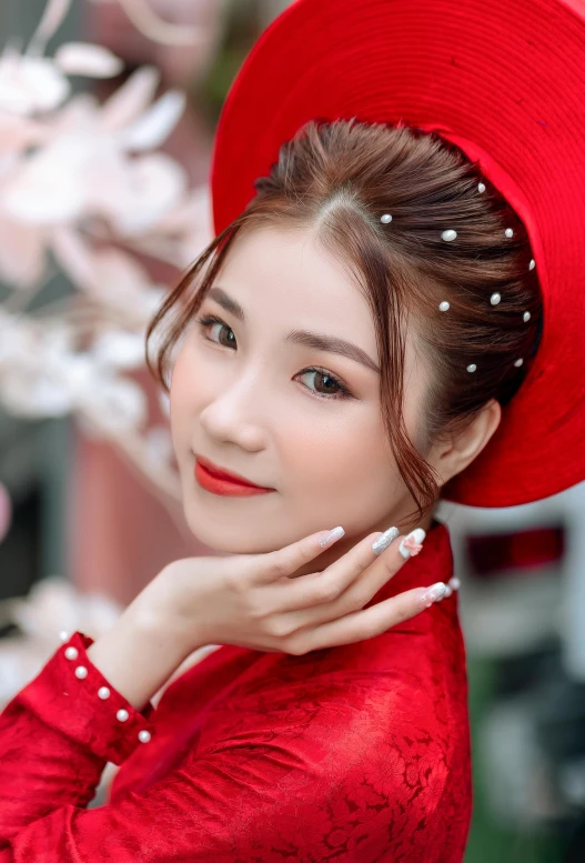 a woman in a red hat poses with her hand near her chin