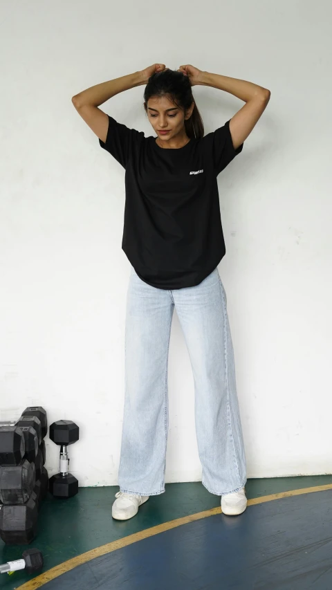 a woman in black shirt standing on the edge of a swimming pool