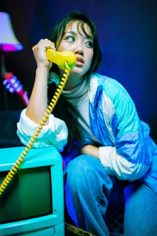 young woman with blue eyes using a yellow telephone