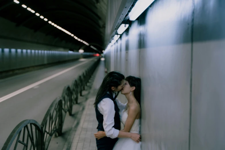 two women standing next to each other and kissing