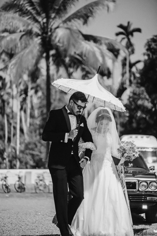 the groom walks his bride down the aisle with an umbrella