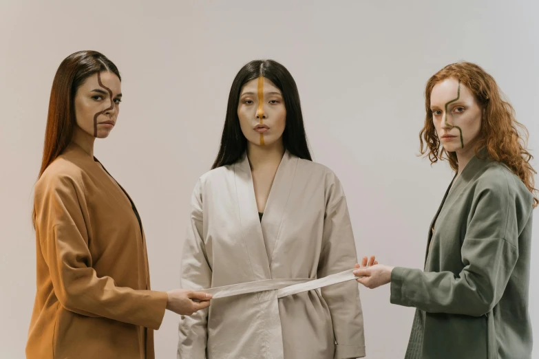 three women are holding scissors and  white ribbons