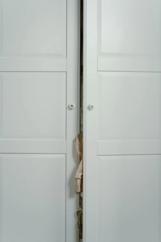 a white closet with several shoes hanging on the wall