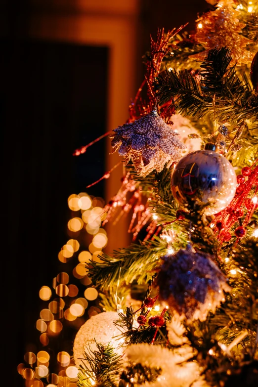 close up of brightly decorated christmas tree with many small lights