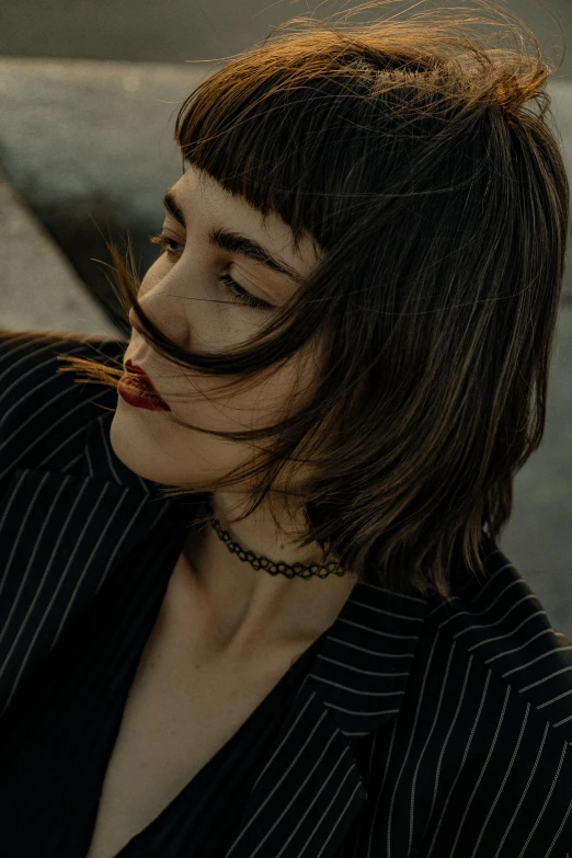 a woman with dark makeup and fake moustache looks to her left