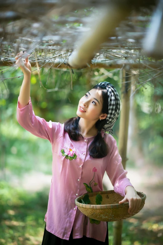 a woman in pink and black holds up an umbrella over her head