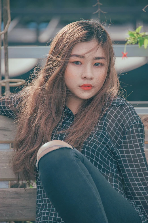 a young woman wearing blue jeans posing for a picture