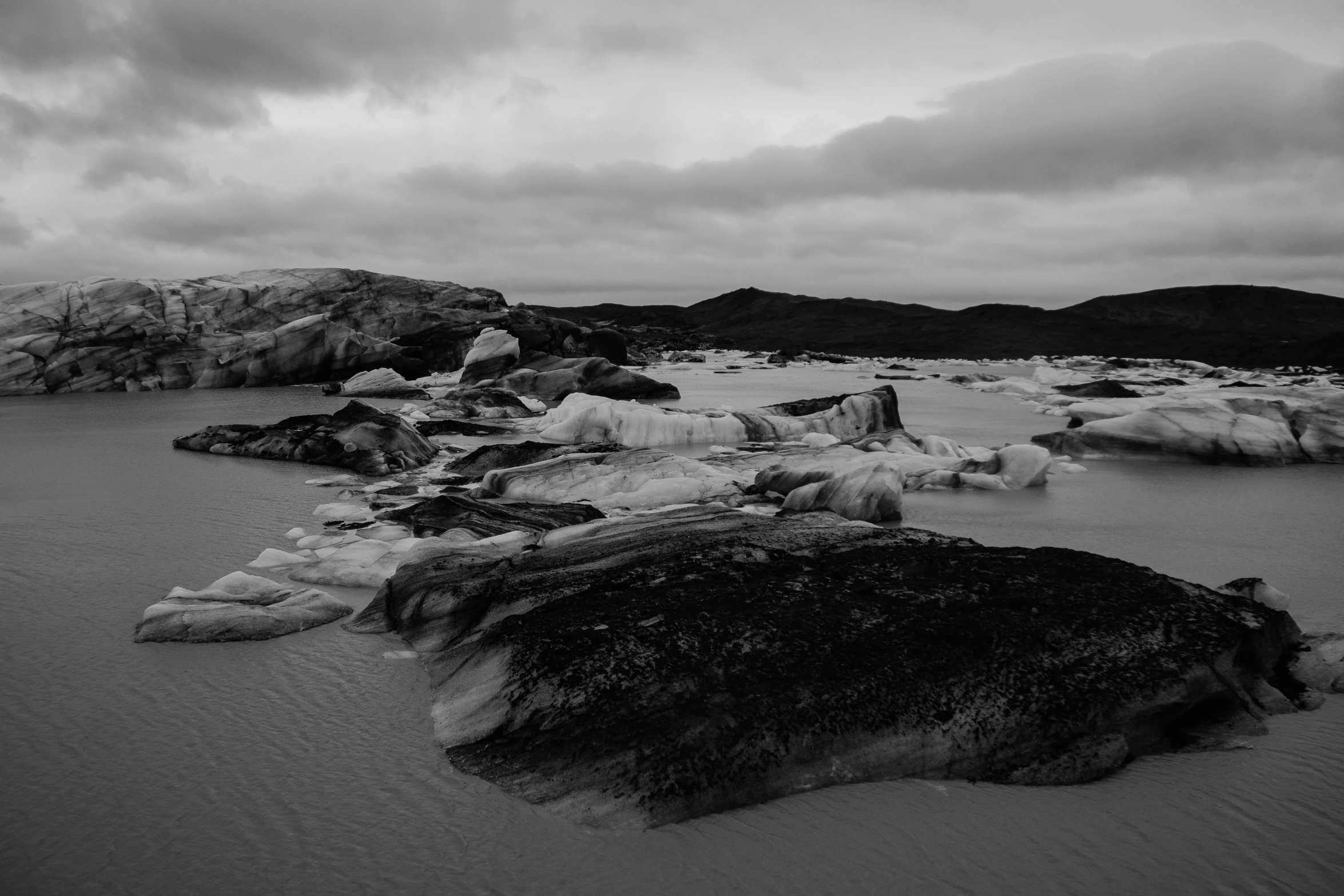 black and white pograph of a couple rocks that are covered in ice