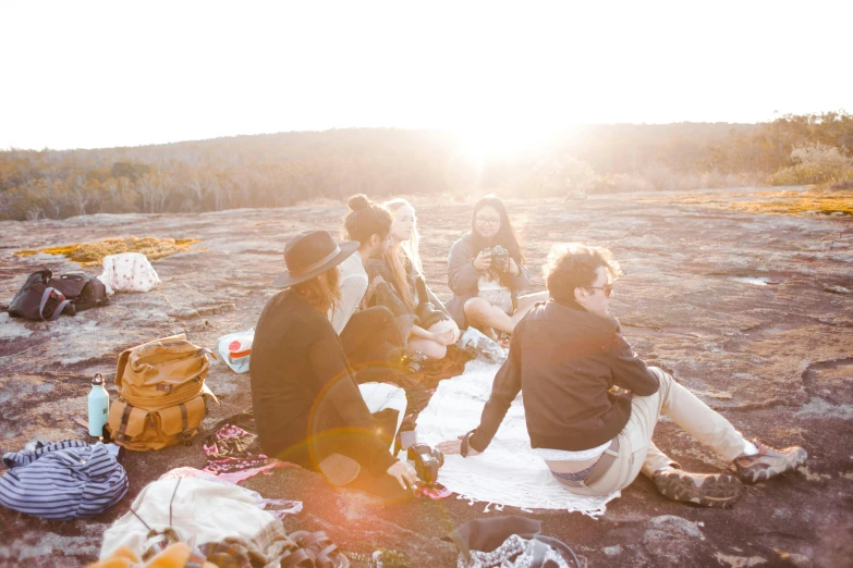 a group of people sitting on top of a stone field