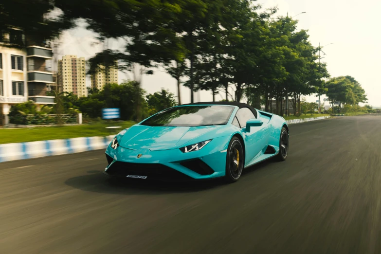 a beautiful blue sports car driving down a road