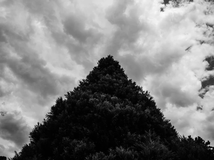 an odd triangular building with lots of dark clouds in the background