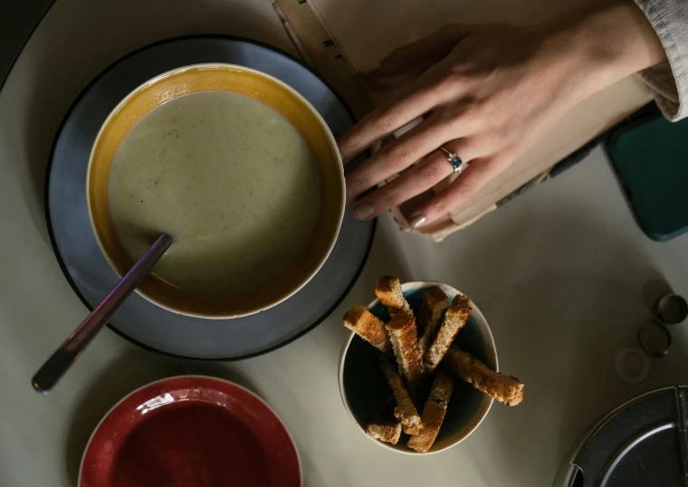 a woman holds the edge of her bowl with bread sticks in it