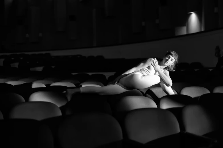 woman in low - sitting position in an empty auditorium