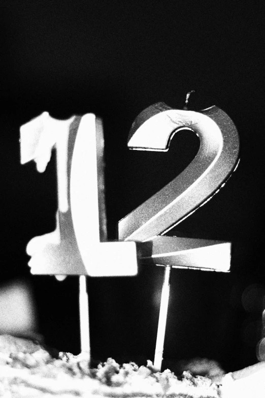 a close up view of the number twelve with two sticks