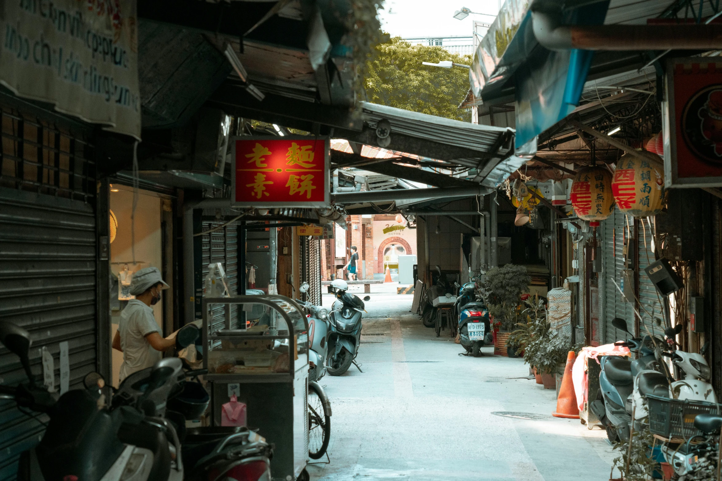 a narrow street with a man walking through it